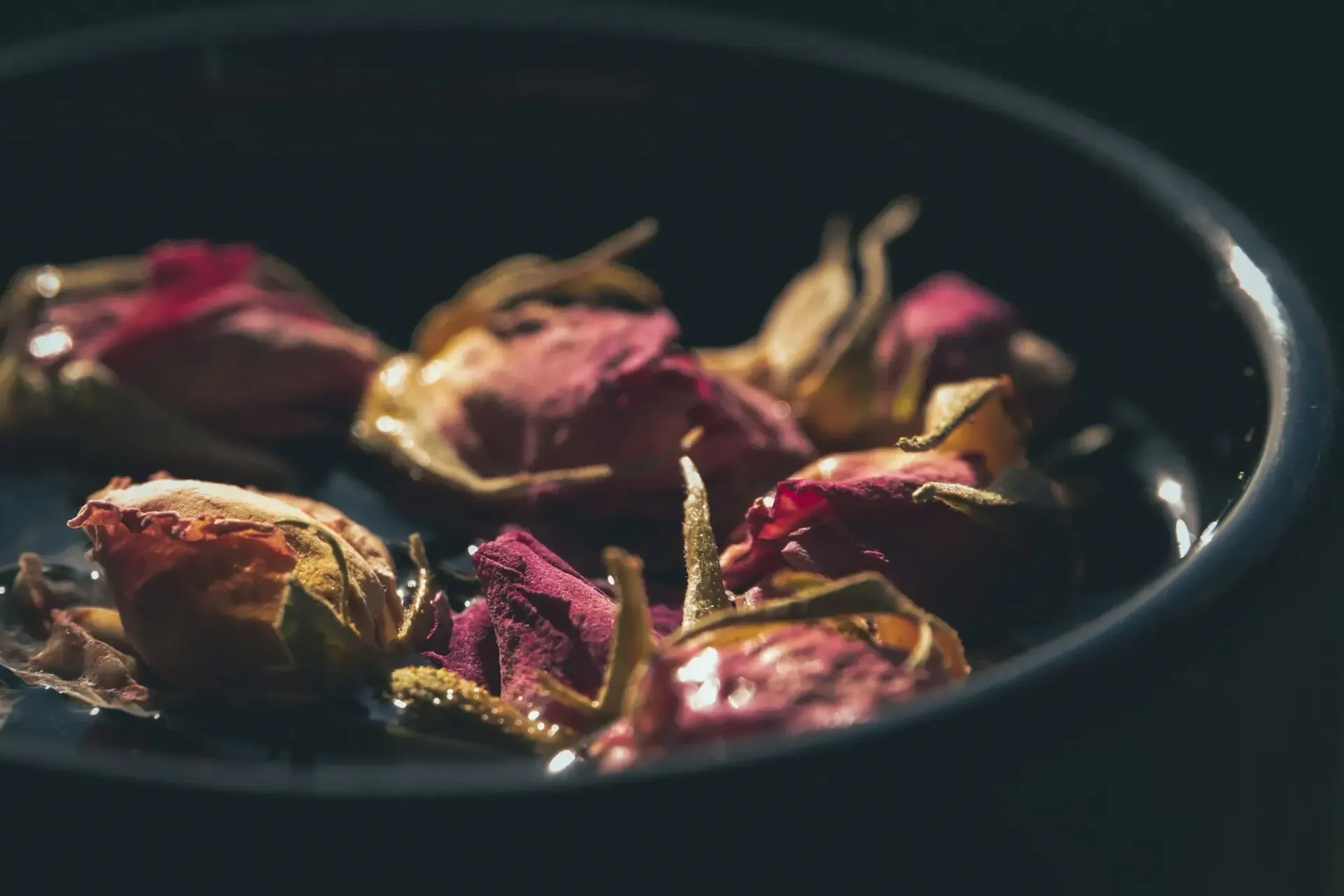 Dried rosebuds in a dark bowl